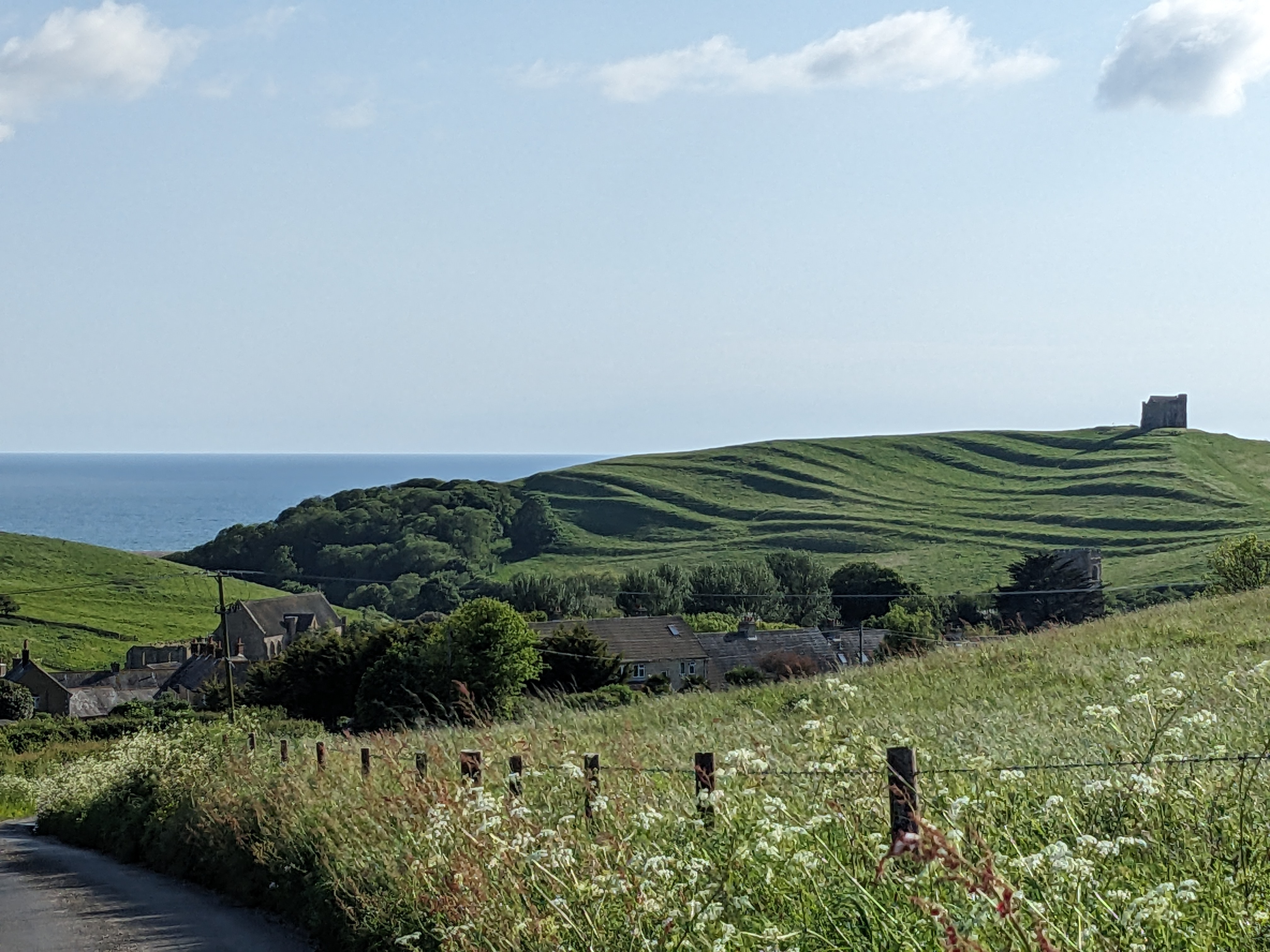View across Abbotsbury village to the chapel hill and sea