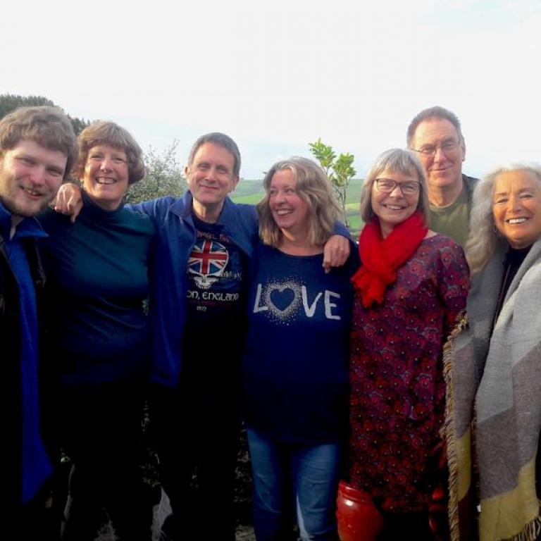 Group of people smiling with arms around each other
